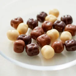 Mix de morceaux de noix de coco enrobés de chocolat noir, au lait ou blanc